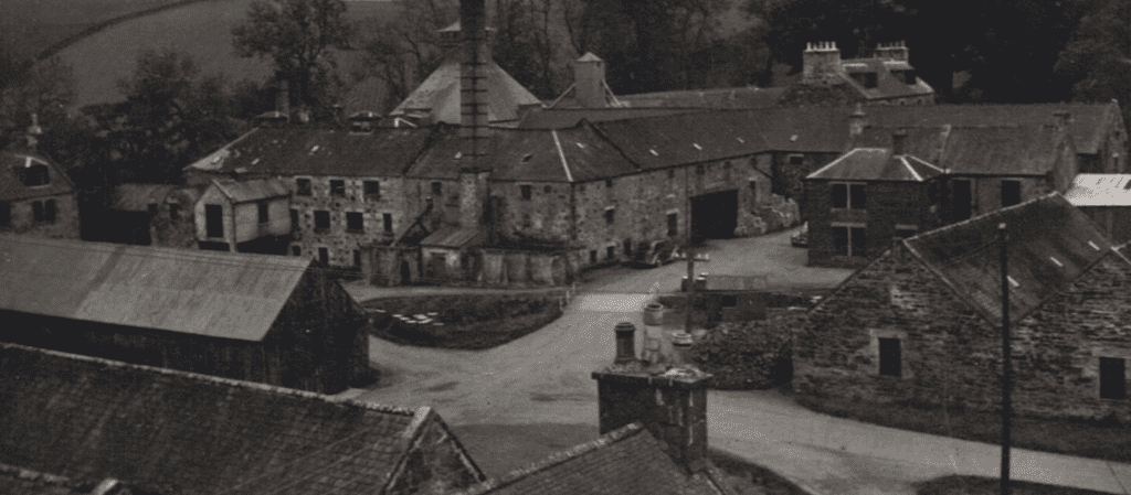 A vintage black and white photo of The Glendronach Distillery stone buildings.
