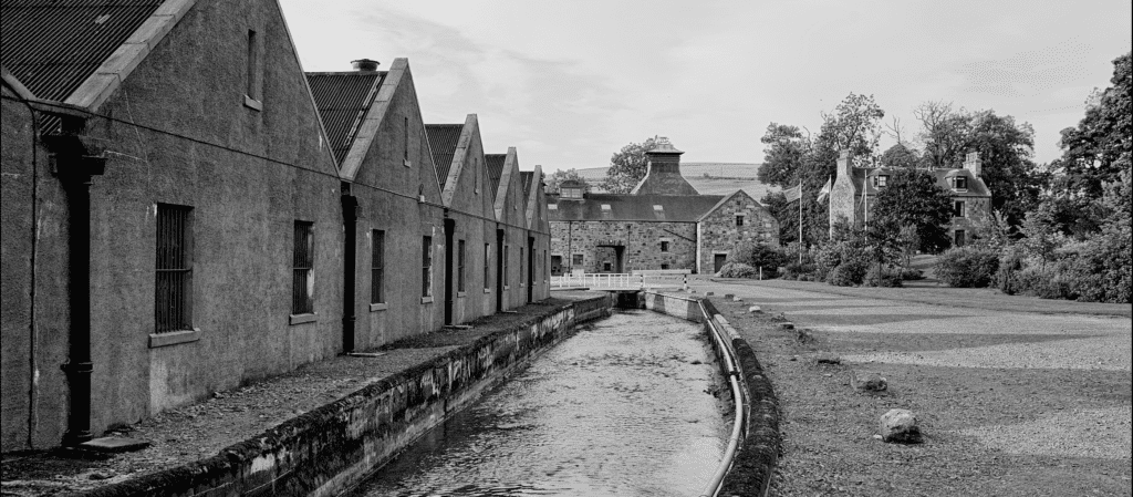 A black and white photo of The Glendronach Distillery stone buildings.